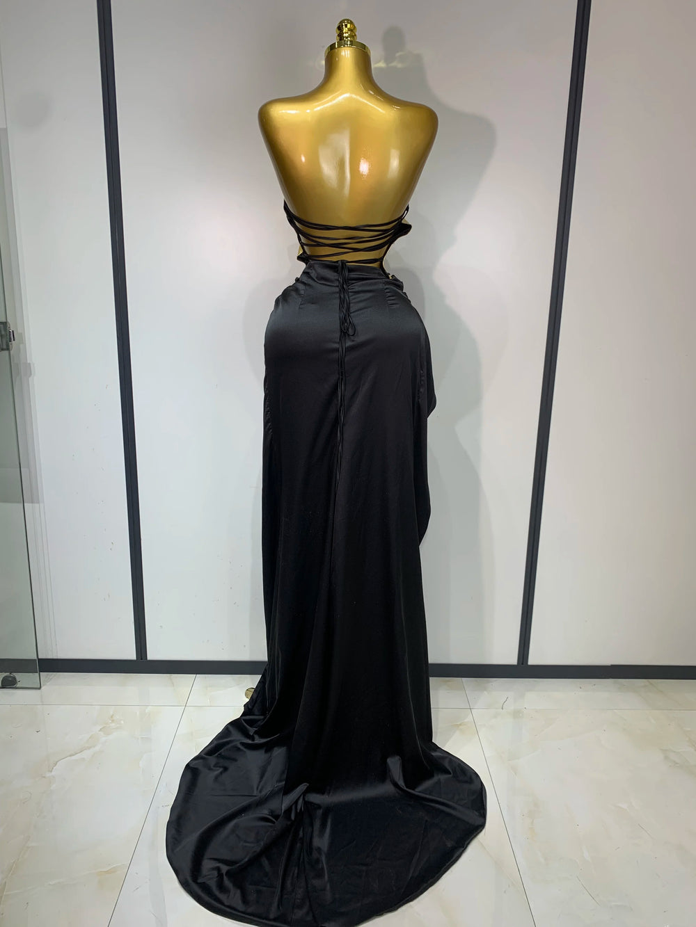 Back view of gold metallic corset top and black draped skirt two-piece set