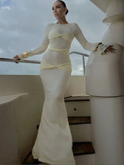 Woman in a white dress standing on a boat with a cloudy sky background