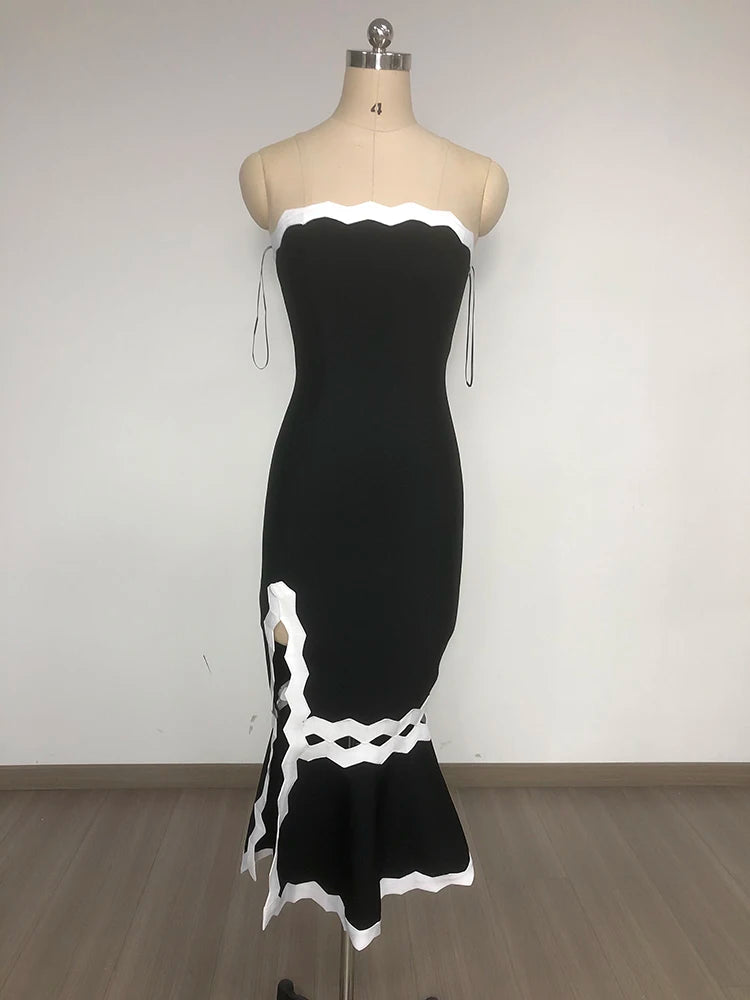 Black dress with white lace details on a mannequin against a plain background