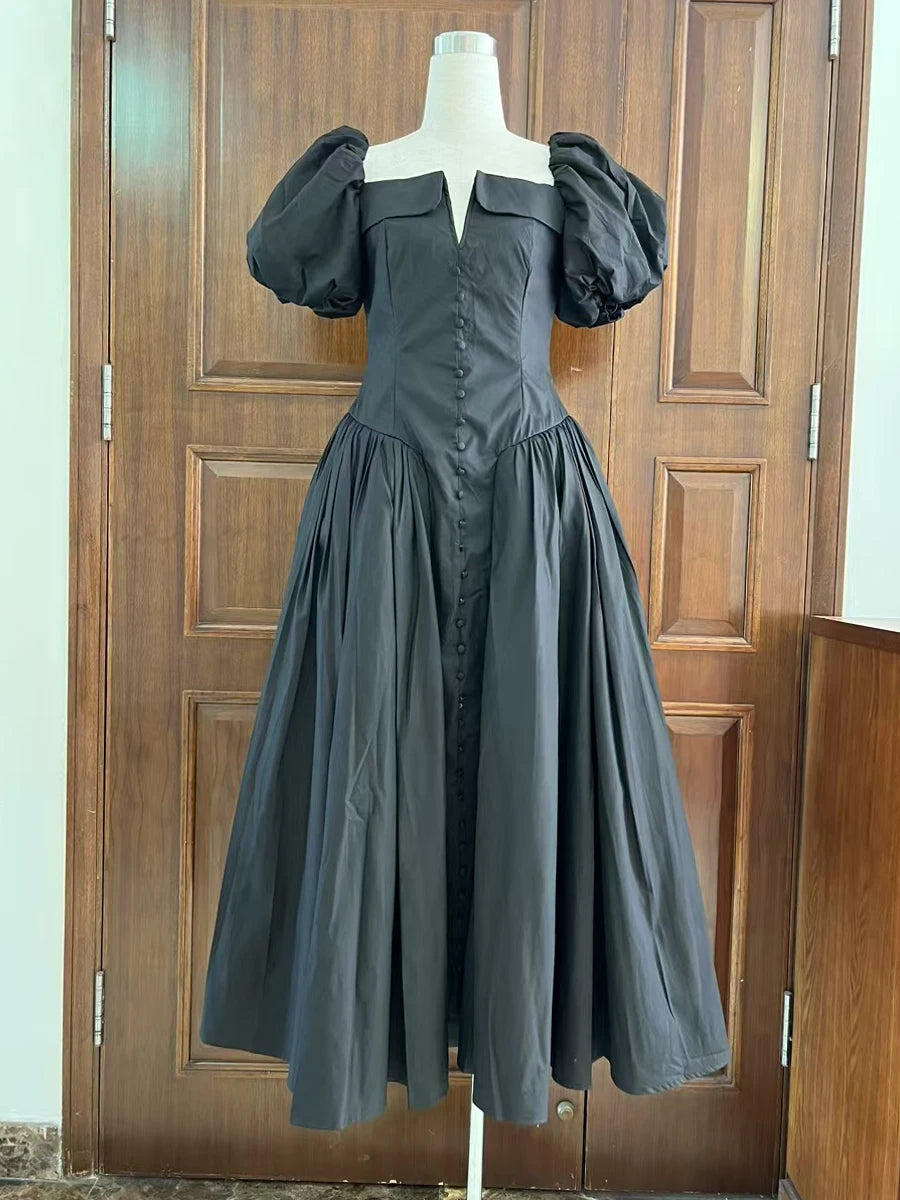 Dark gray dress on a mannequin against a wooden door background