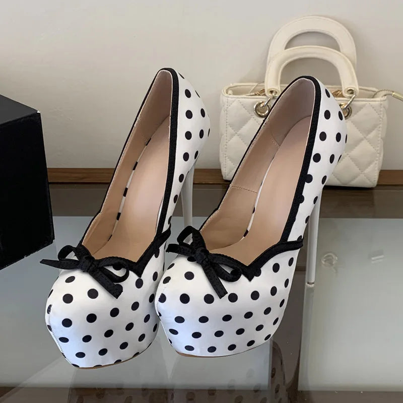Close-up of white polka dot platform pumps with black trim