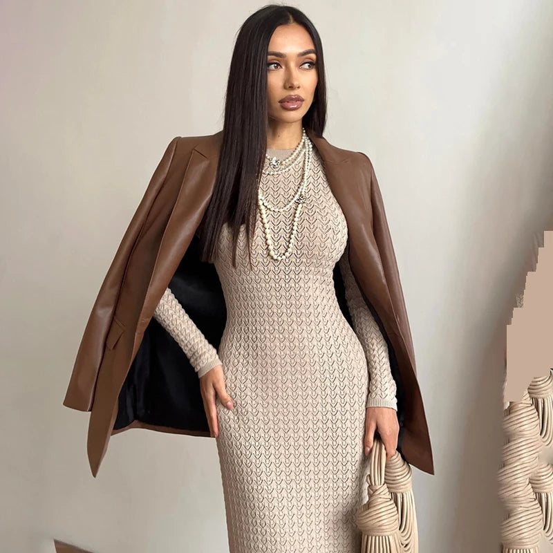Woman wearing a brown coat over a beige dress with a neutral background