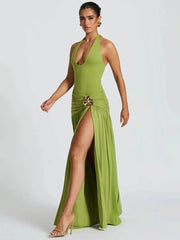 Woman wearing a green evening gown with a high slit on a white background