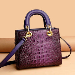  Close-up of the crocodile pattern texture on a top handle handbag, highlighting the luxurious detailing and craftsmanship. Purple 2