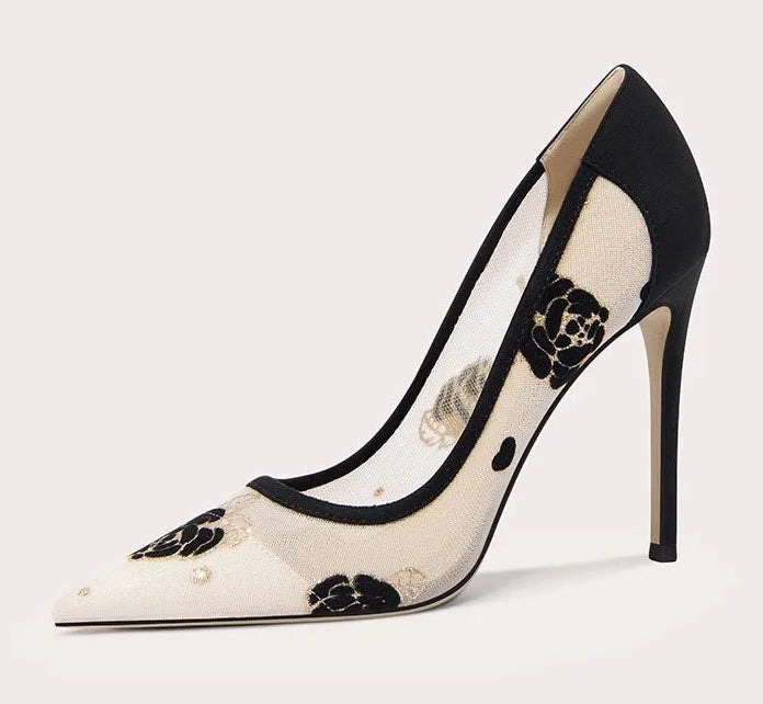 Black and white high-heeled shoe with floral design on a light gray background