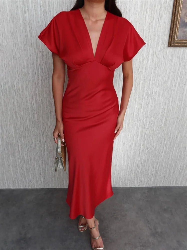 Woman in a red flutter sleeve satin maxi dress
