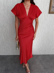 Woman in a red flutter sleeve satin maxi dress