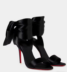 Pair of black satin stiletto heels with large bow ankle straps