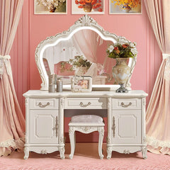 Decorative vanity table with mirror, stool, and floral arrangements in a pink room.