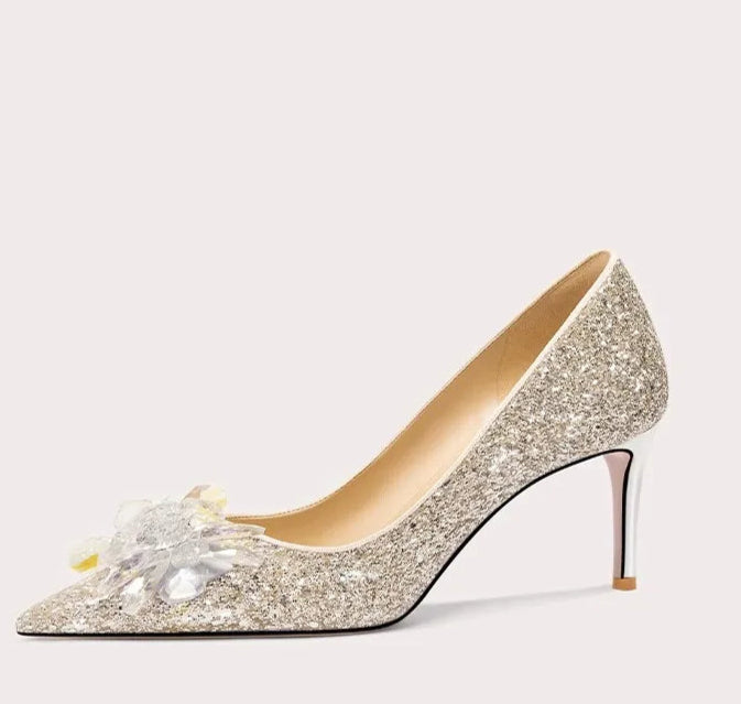 Sparkly high-heeled shoe with decorative element on a white background