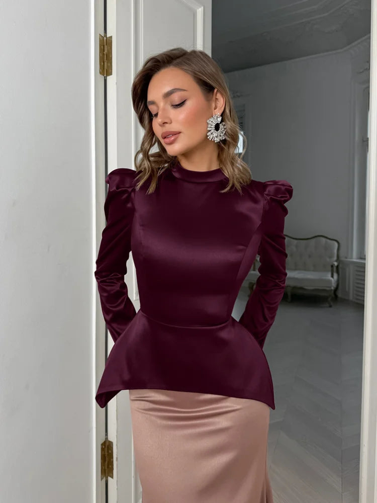 Woman wearing a burgundy top and pink skirt in an indoor setting