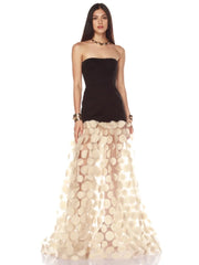 Woman wearing a black top and beige floral skirt on a white background