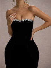 Black strapless dress with floral embellishments on a neutral background