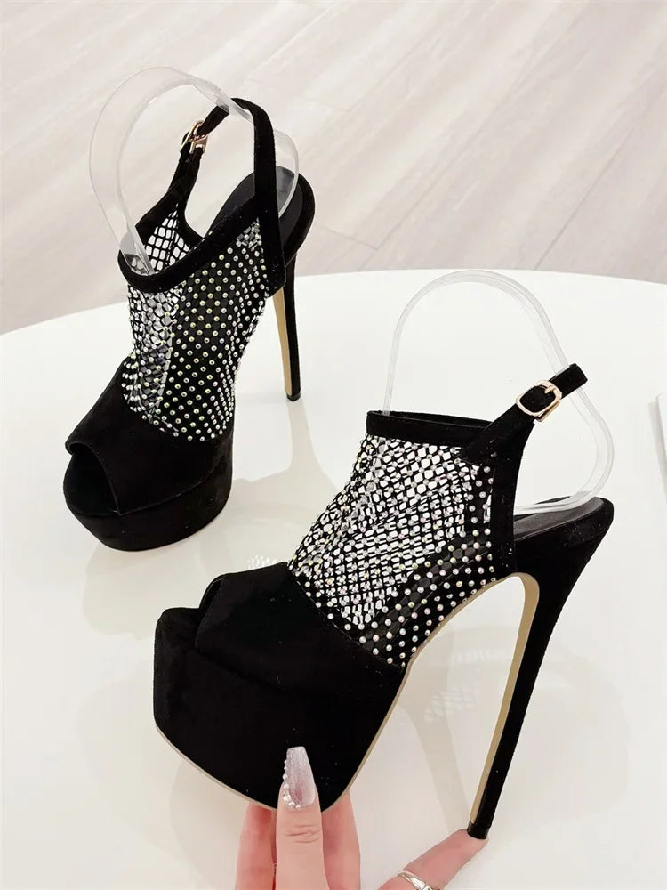 Black high-heeled shoes with rhinestone detailing on a white background