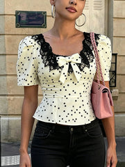 Polka dot peplum top with lace neckline and bow