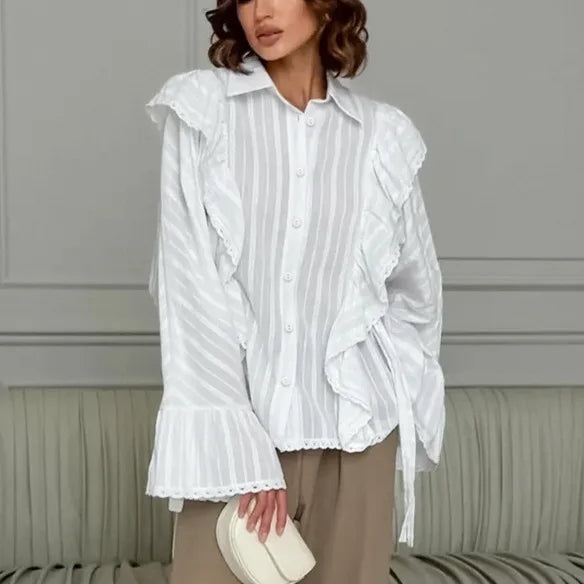 Woman wearing a white ruffled blouse against a neutral background