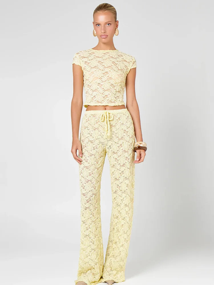 Sheer yellow lace cropped t-shirt and wide leg pants set on a model.