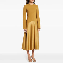 Model wearing a mustard patchwork A-line midi dress with full sleeves and mid-calf hem, studio shot