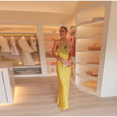 Woman in a yellow dress standing in a well-lit closet with shelves and clothes.