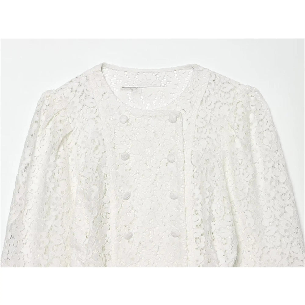 Close-up of the neckline and buttons on a white lace double-breasted cropped jacket.