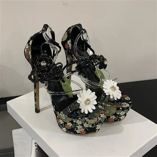 Black floral platform stiletto heels with lace-up ankle straps and flower embellishments.
