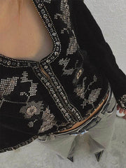 Close-up of the intricate silver embroidery on the velvet cropped jacket.