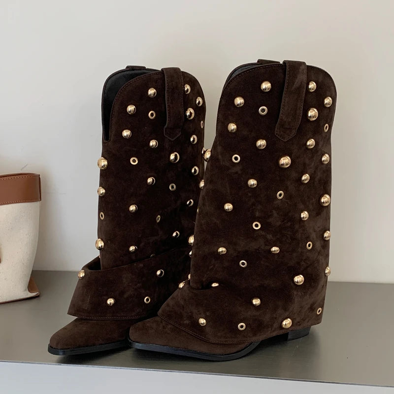 Close-up of brown suede western boots with gold stud details.