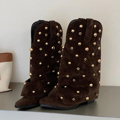 Close-up of brown suede western boots with gold stud details.