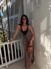 Woman leaning on a railing in a leopard print maxi dress