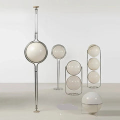 A modern Nordic glass floor lamp in the shape of a planet, illuminating a minimalist living room. A