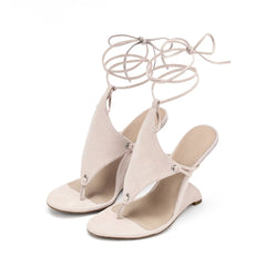 Pair of beige high-heeled sandals with tie-up laces on a white background