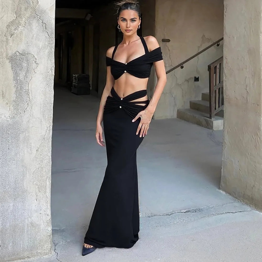 Woman in a black evening gown standing in an outdoor setting.