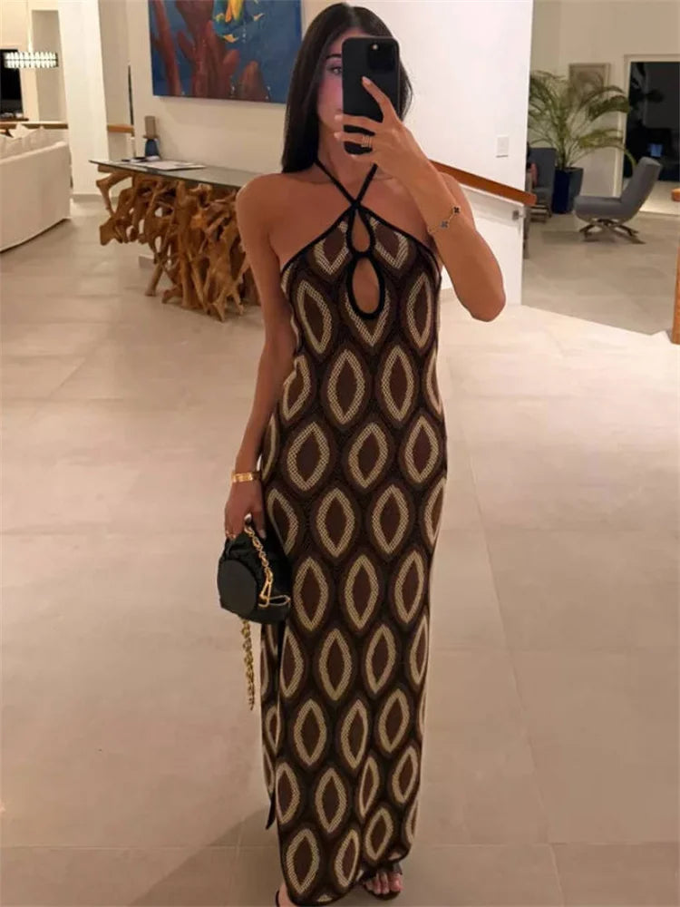 Woman taking a mirror selfie wearing a patterned dress in an indoor setting.