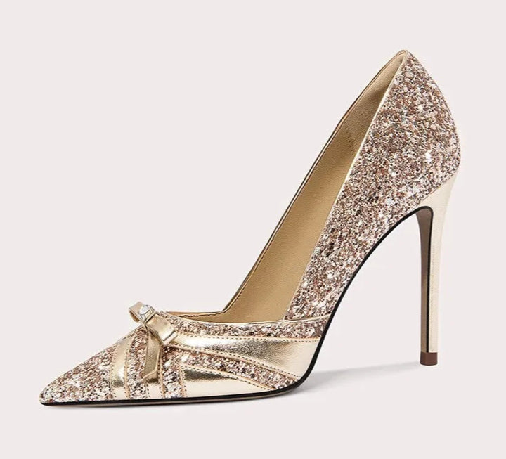 Gold glitter high-heeled shoe with a bow on a white background