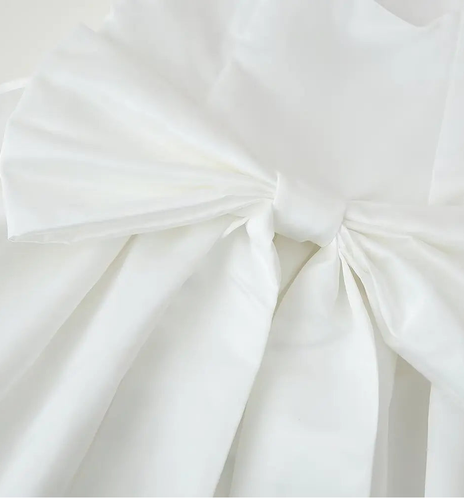 Close-up of a white fabric with a large bow on a light background