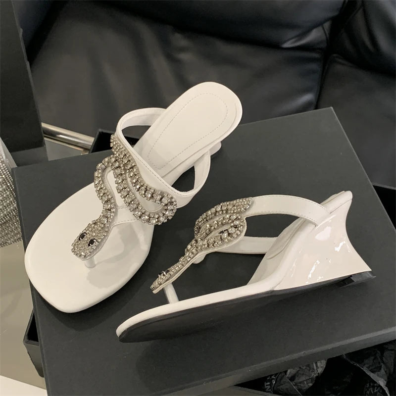 White sandals with embellishments on a black surface