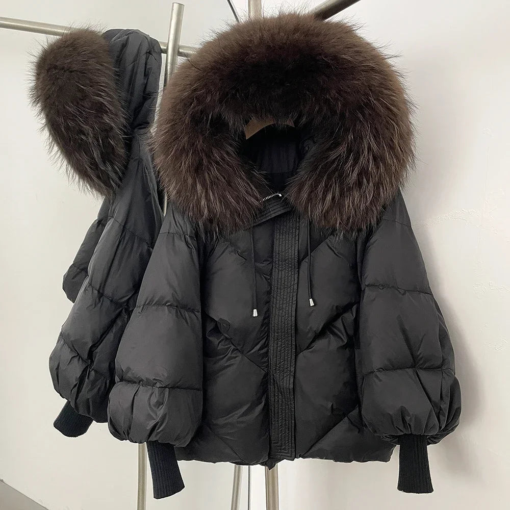 Black puffer jacket with large fur hood on a white background