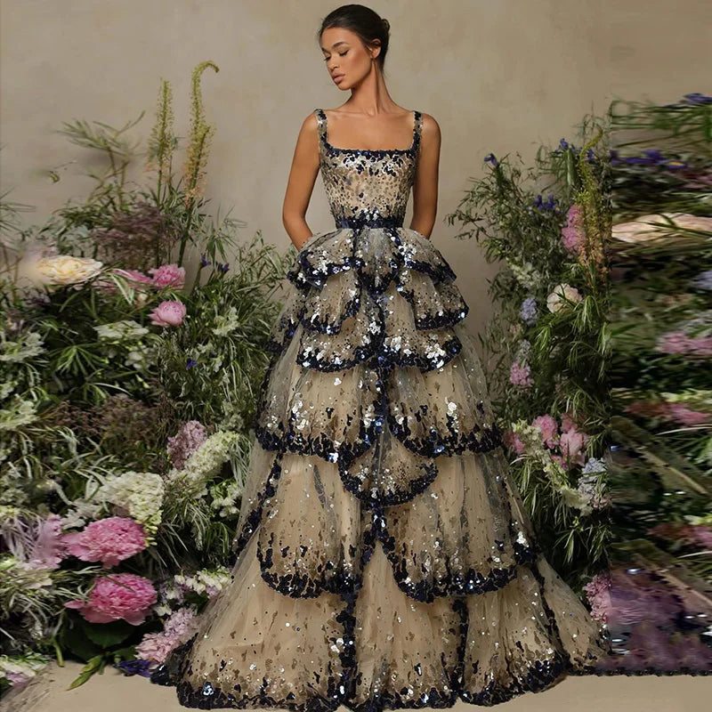 A model wearing a shimmering sequin butterfly layered gown with a flowing silhouette, perfect for special occasions. 7