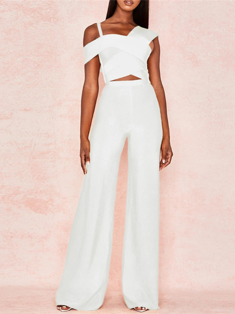 White off-shoulder jumpsuit on a model against a pink background