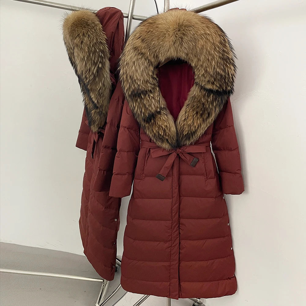 Red puffer coat with fur collar on a rack against a white background