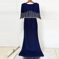 Navy blue evening gown with beaded top on a white background