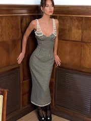 Woman wearing a black and white checkered dress in a wooden room.