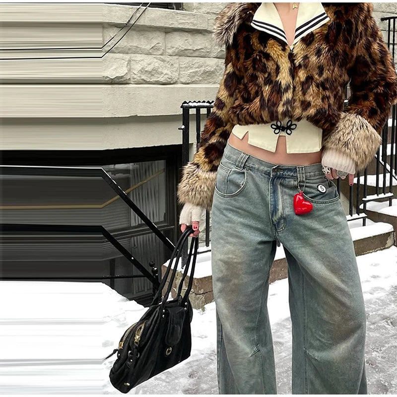 Person wearing a leopard print coat and jeans with a black bag, standing on a snowy ground.