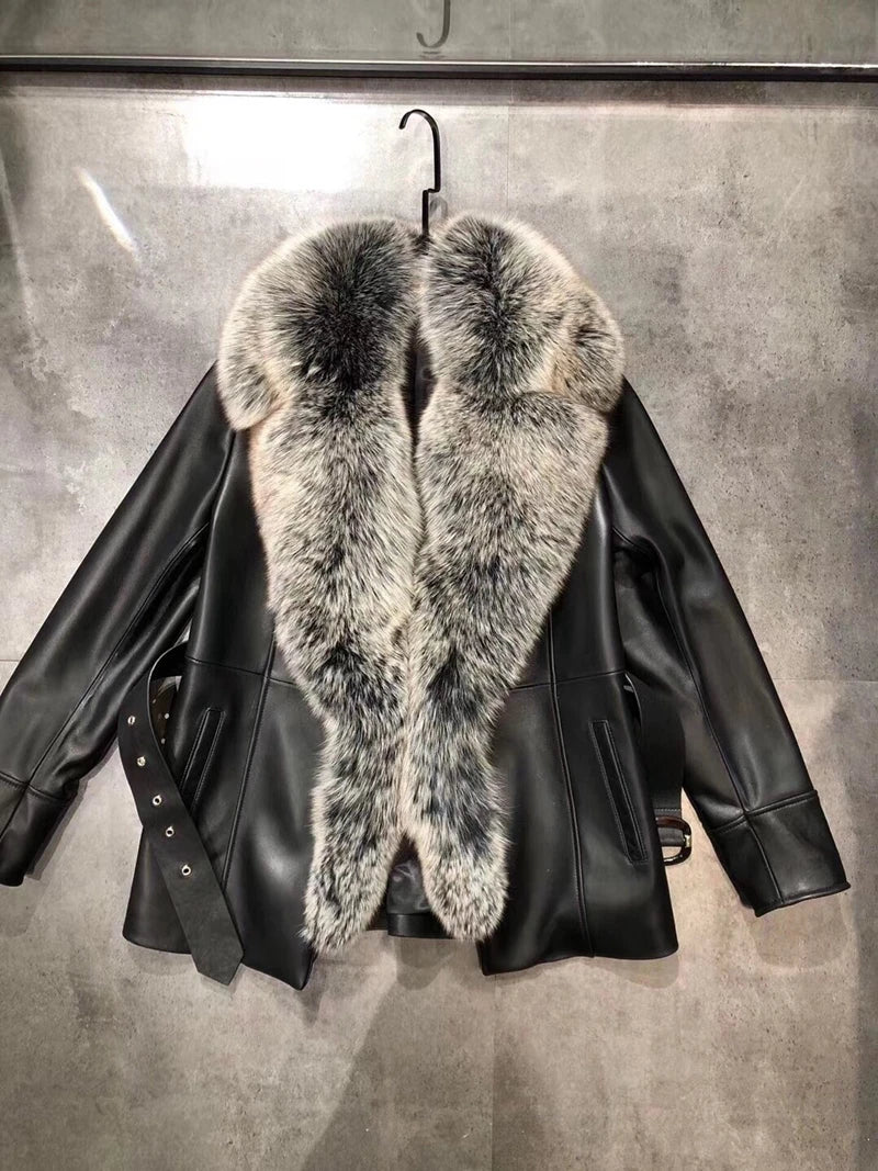 Black leather jacket with fur collar on a gray background