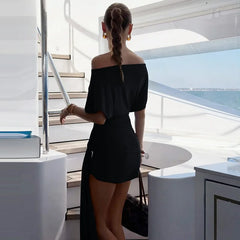 Woman in a black off-shoulder dress on a yacht deck with ocean view