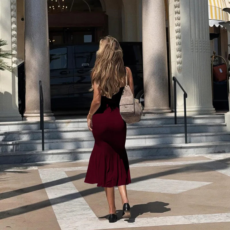 Woman in a red dress standing on steps in front of classical architecture