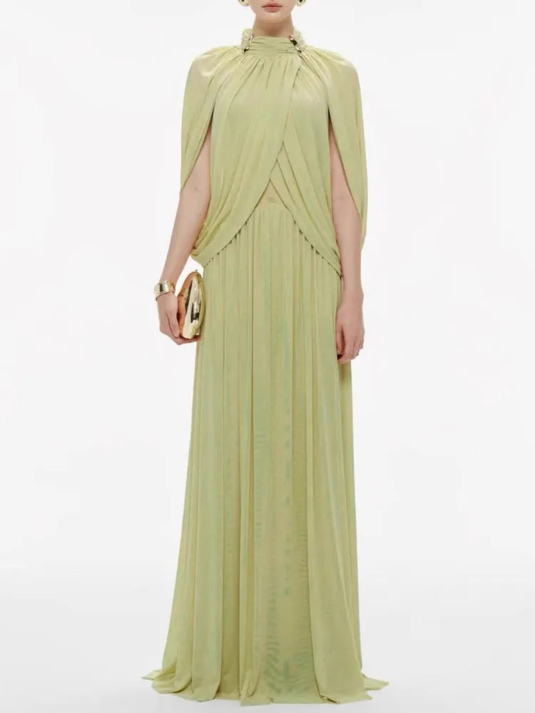 Woman wearing a light green evening gown with a cape on a white background