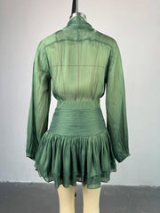 Green dress on a mannequin against a plain background