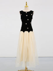 Black top with silver buttons and beige skirt on a mannequin against a white background