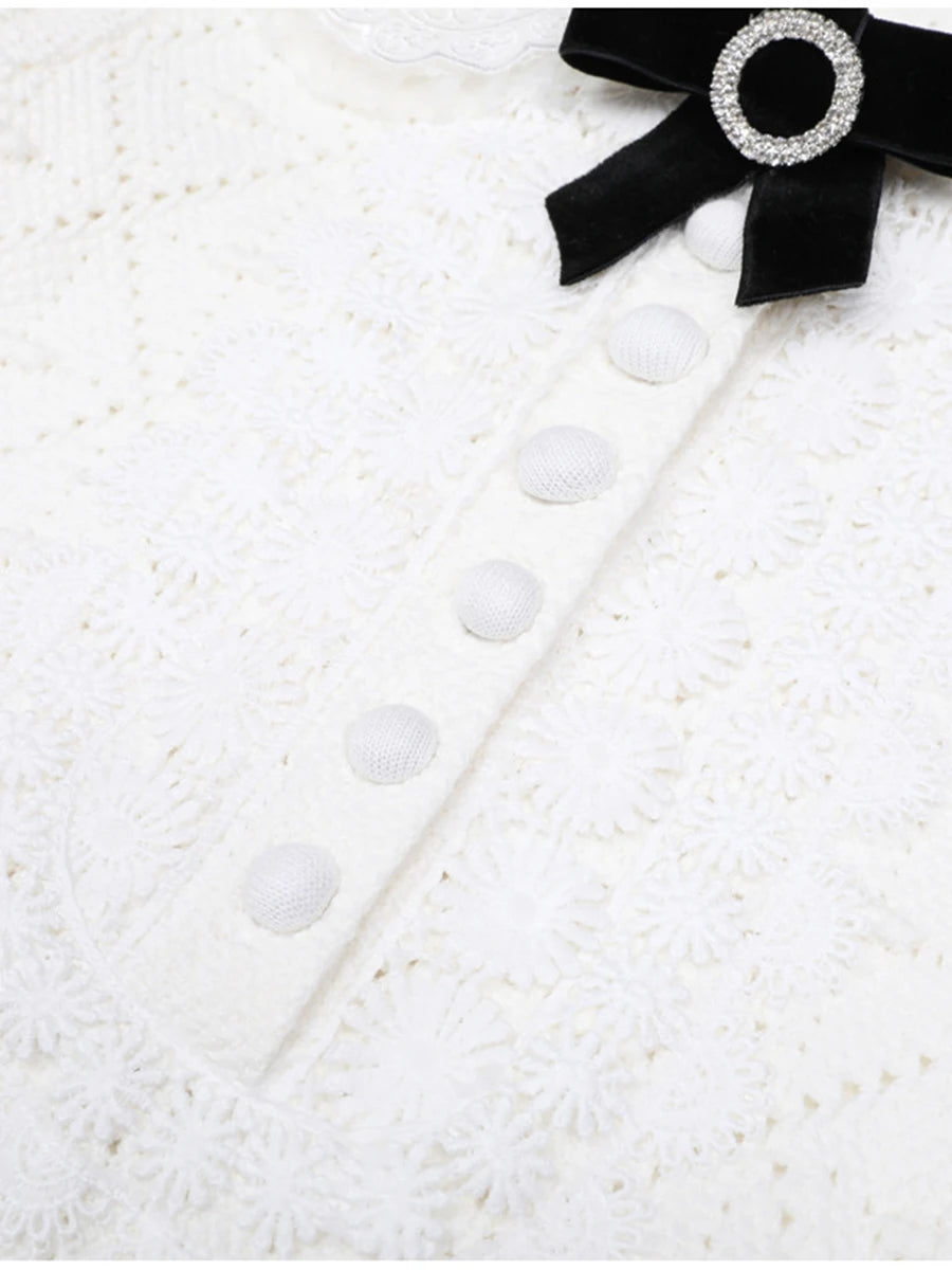 Black bow with a decorative brooch on a textured white surface